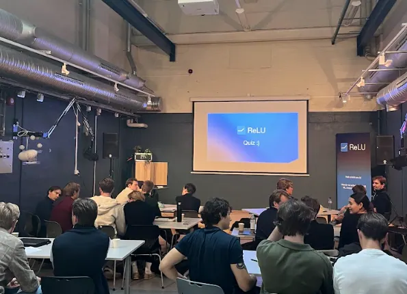 ReLU Quiz 3 projected on screen with members seated at tables.